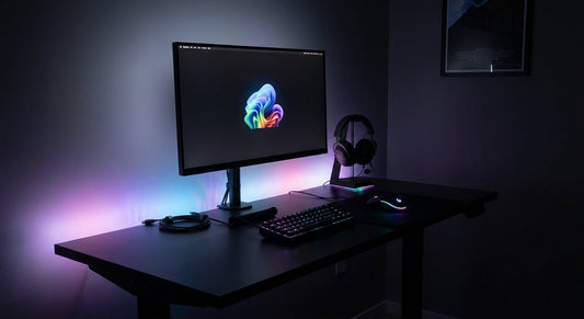 A dark gaming desk illuminated by colorful RGB lighting from a mechanical keyboard, gaming mouse, and headset arranged in a clean, organized setup.