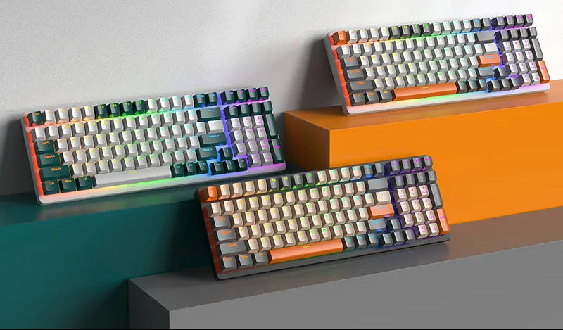Three colorful mechanical keyboards with RGB backlighting on display, featuring various keycap designs.